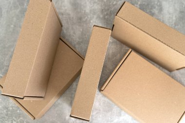 Kraft karton kutularının dokulu bir yüzeye yerleştirilmiş havadan perspektifi. Sürdürülebilir ambalaj, hediye, nakliye ve çevresel bilinçli depolama çözümleri için ideal. 