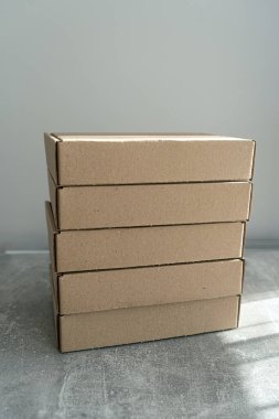 Kendi kendine monte edilen kraft karton kutular desenli bir yüzeye yerleştirilmiş. Paketleme, hediye paketleme ve nakliye için ideal. İşletmeler ve tatil hazırlıkları için sürdürülebilir bir seçim.
