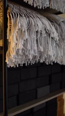 Rafta istiflenmiş yoga malzemeleri: yumuşak katlanmış battaniyeler ve eko tıpa blokları. Yoga ya da meditasyon stüdyosundaki dikkatli iç dekorasyonun ayrıntıları..