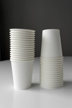 Beyaz kağıt bardak raflarının minimalist görüntüsü. Sürdürülebilir yaşam, kahve dükkanları, etkinlikler veya markalaşma modelleri için eko-bilinçli tasarım.