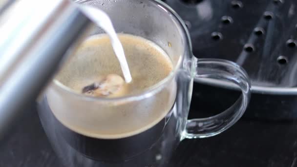 卡布奇诺的制作过程的特写 把奶油牛奶倒入一杯黑咖啡中 晨咖啡 — 图库视频影像