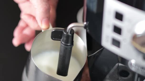 コーヒーメーカーのカプシネートで金属製のマグカップでミルクを凍らせる男 ミルクでマグカップを閉じる 朝のコーヒー — ストック動画