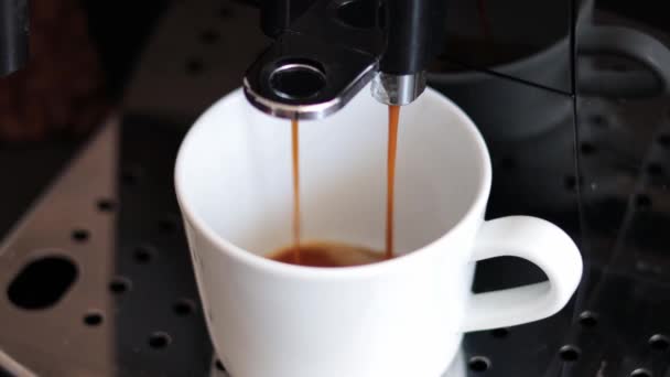 Egy Modern Kávéfőző Egy Fémtartón Álló Közeli Fehér Pohárba Önti — Stock videók