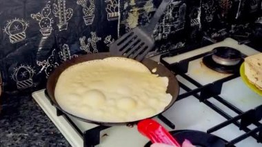 Kızartma tavasında büyük yuvarlak bir gözleme. Krepten duman yükselir. Delikli gözleme. Maslenitsa. Rus geleneği. Yemek pişirme.