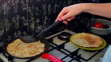 Kızartma tavasında büyük yuvarlak bir gözleme. Krepten duman yükselir. Delikli gözleme. Maslenitsa. Rus geleneği. Yemek pişirme.