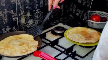 Kızartma tavasında büyük yuvarlak bir gözleme. Krepten duman yükselir. Delikli gözleme. Maslenitsa. Rus geleneği. Yemek pişirme.