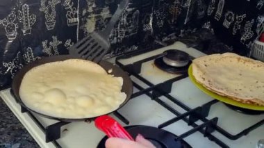 Kızartma tavasında büyük yuvarlak bir gözleme. Krepten duman yükselir. Delikli gözleme. Maslenitsa. Rus geleneği. Yemek pişirme.