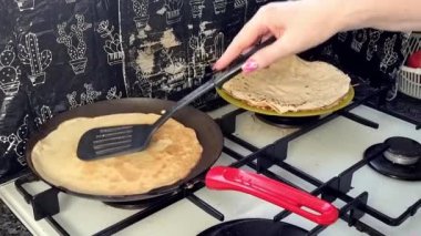 Kızartma tavasında büyük yuvarlak bir gözleme. Krepten duman yükselir. Delikli gözleme. Maslenitsa. Rus geleneği. Yemek pişirme.
