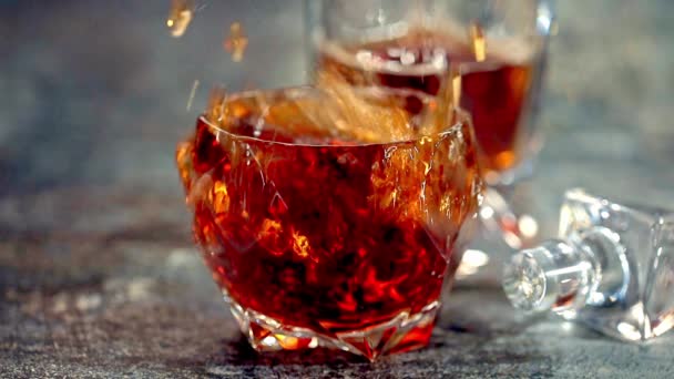 冰块掉进了一杯威士忌里 慢动作在慢动作中 威士忌溅到一张木制桌子上 威士忌 — 图库视频影像