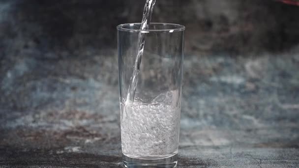 Kohlensäurehaltiges Kaltes Mineralwasser Wird Ein Glas Auf Dunklem Hintergrund Gegossen — Stockvideo