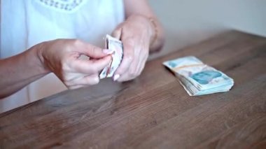 Bir kadının el ele tutuşup 200 lira banknot sayması. Para.