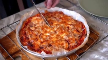 Lezzetli, hazır İtalyan pizzası ve ton balığı bıçakla parçalara ayrılır. Pizza..