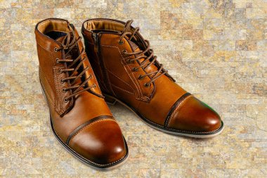 Taş zeminde bir çift dana derisi bot. Yatay çekim. Erkek ayakkabısı fikirleri.