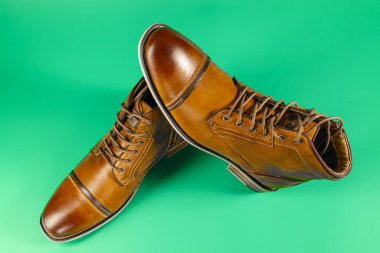 Yeşil arka planda bir çift kaliteli dana derisi bot. Yatay çekim. Erkek ayakkabısı fikirleri.