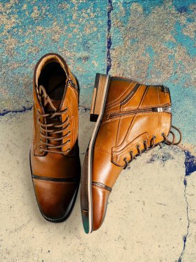 Bir çift kaliteli dana derisi bot ve çok renkli bir arka plan. Dikey çekim. Erkek ayakkabısı fikirleri.