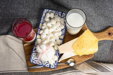 Yahudi bayramını kutluyoruz Shavuot. Kosher taze süt ürünleri, süt ve peynir, ahşap arka plan. Ahşap arka planda süt ürünleri. Shavuot konsepti. Yukarıdan görüntüle.