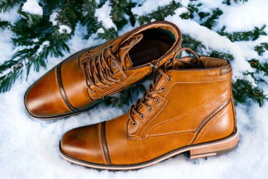 Kar arkaplanlı bir çift kaliteli dana derisi bot. Yatay çekim. Erkek ayakkabısı fikirleri.