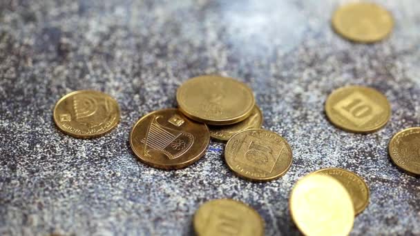 新しいイスラエルのシェケル硬貨はゆっくりと暗い表面に落ちる — ストック動画