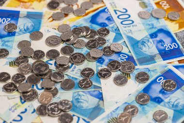 Yeni İsrail sikkeleri ve banknotları masanın üzerinde..