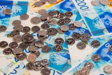 Yeni İsrail sikkeleri ve banknotları masanın üzerinde..