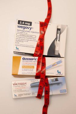 Still life of the big three injectable prescription weight loss medicines. Ozempic, Victoza and Wegovy. clipart