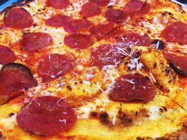 Wood peynirli ve pepperonili pizza ateşledi, bütün pizza turtası. Abur cubur, kalorik pizza, pepperonili pizza. Yağlı biberli turtayı kapat. Yağlı biberli ve peynirli pizza. Üstünde rendelenmiş parmesan peyniri var..