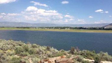 Trenden Heber Vadisi ve Deer Creek Barajı manzarası. Rayların kenarındaki bir göl ve demiryolu hattını geçmek. Heber Vadisi Utah hareket halindeki bir trenden görüldü..