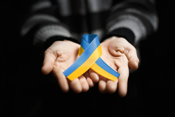 Рука Ребенка Держит Голубую Желтую Украинскую Ленту Темном Фоне Концепция — стоковое фото