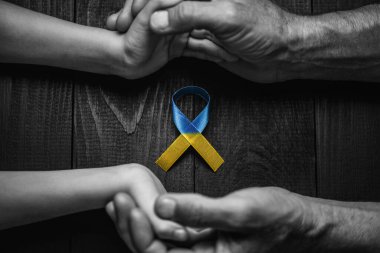 Erkek elleri, çocukları siyah beyaz arka planda, tahta bir arka planda tutuyor. konsept yardıma ve desteğe ihtiyaç duyar, gerçek kazanır.