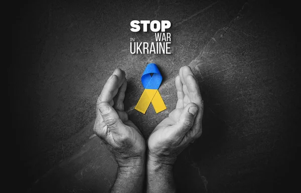 大理石の背景に黄色と青のリボンが付いている男性の手は ウクライナの黒と白の色で戦争を停止します コンセプトは助けとサポートを必要とし 真実は勝利します — ストック写真