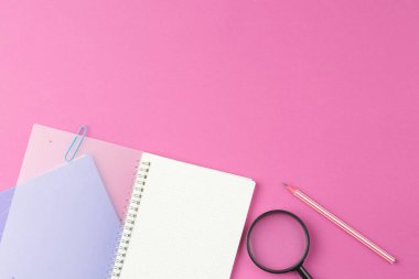 Leylak izole arka planda büyüteç ve kalemle okul defterini aç. Üst Manzara. Okul masası kavramı. Düz yatıyordu.