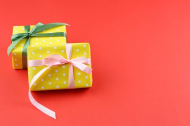 Üzerinde kırmızı saten fiyonk olan çizgili kağıtta mevcut kutu. Bir çift için hediye. Üst görünüm.