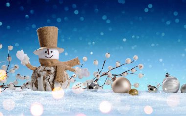 Kar ve mavi arka planda Baubles ile Kardan Adam.