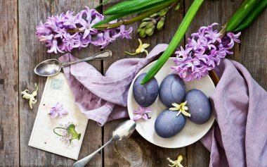 Ahşap bir masada renkli Paskalya yumurtaları. Paskalya yumurtalı çiçekler..