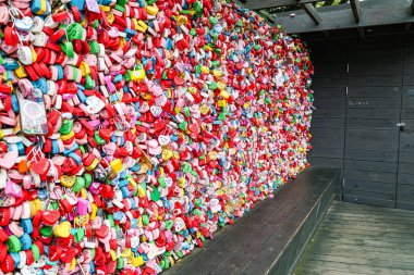 Güney Kore, Seul 'deki Namsan Seul Kulesi' nde asma kilitlerle kaplı renkli duvarın tam kare görüntüsü. Her kilitte bu ünlü romantik mekanda aşkı ve bağlılığı simgeleyen el yazısıyla yazılmış isimler ve mesajlar var.