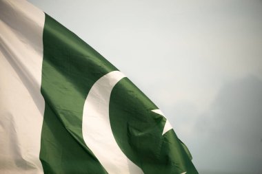 Pakistan 'ın ulusal bayrağı mavi gökyüzünde bulutlarla dalgalanıyor