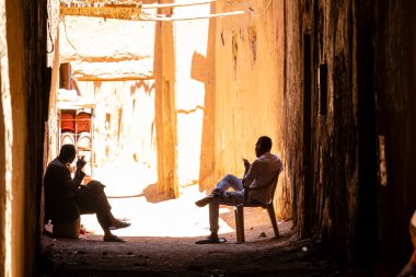two men in the shade, ksar of Tamegroute, Draa Valley, Morocco, Africa