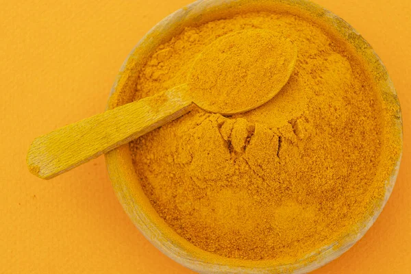 stock image ground turmeric on orange background