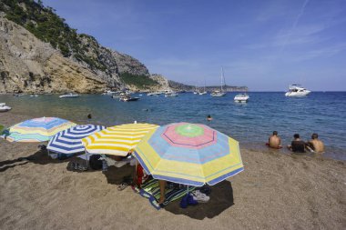 Sombrillas en la playa de Es Coll Baix, a los pie del Puig de Sa Talaia, Alcudia, islas baleares, İspanya