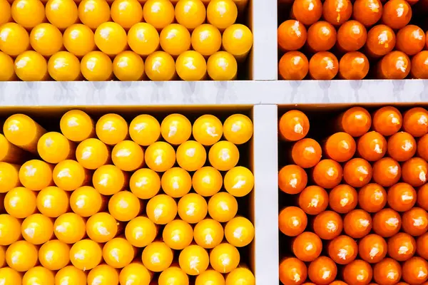 stock image Coloured candles on a shelf, orange and yellow, Girona, Catalunya, Spain