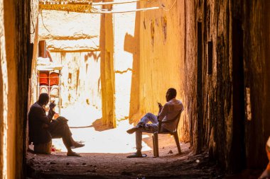 two men in the shade, ksar of Tamegroute, Draa Valley, Morocco, Africa