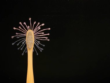 Siyah üzerine bambu diş fırçası. Holografik çizik kağıdına çizilmiş karahindiba çiçeği. Plastik kavram yok, sıfır atık.