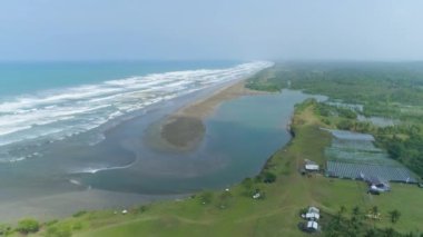 Plaj manzarası. Beyaz kumlu plaj manzarası. Güneşli bir günde dalgalı güzel denizin havadan manzarası. Yukarıdan Aşağıya Kuş Gözü Görünümü
