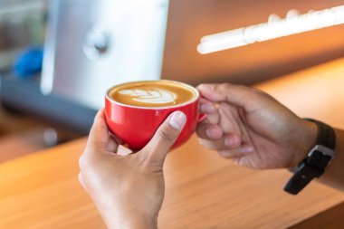 Female hands holding cup of coffee on table bar. perspective view. coffee shop. clipart