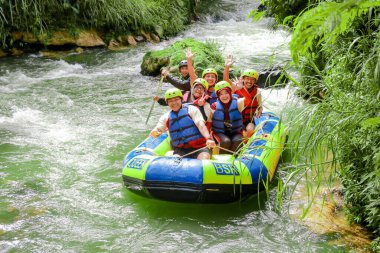 Pangalengan, Bandung-Endonezya Aralık 2022: Bir grup erkek ve kadın nehir üzerinde rafting yapıyorlar, ekstrem ve eğlenceli spor. Bir grup insan su sporları rafting