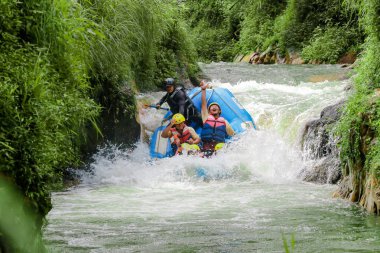 Pangalengan, Bandung-Endonezya Aralık 2022: Bir grup erkek ve kadın nehir üzerinde rafting yapıyorlar, ekstrem ve eğlenceli spor. Bir grup insan su sporları rafting