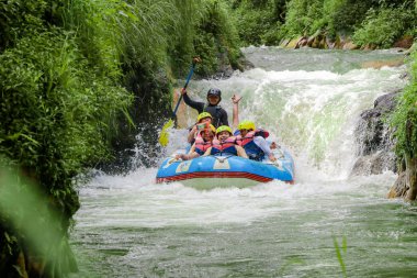 Pangalengan, Bandung-Endonezya Aralık 2022: Bir grup erkek ve kadın nehir üzerinde rafting yapıyorlar, ekstrem ve eğlenceli spor. Bir grup insan su sporları rafting