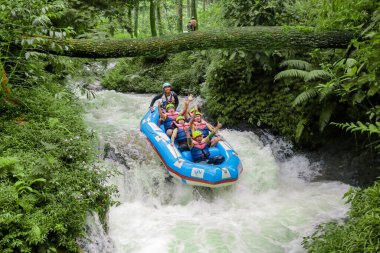 Pangalengan, Bandung-Endonezya Aralık 2022: Bir grup erkek ve kadın nehir üzerinde rafting yapıyorlar, ekstrem ve eğlenceli spor. Bir grup insan su sporları rafting