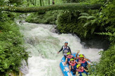 Pangalengan, Bandung-Endonezya Aralık 2022: Bir grup erkek ve kadın nehir üzerinde rafting yapıyorlar, ekstrem ve eğlenceli spor. Bir grup insan su sporları rafting