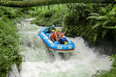 Pangalengan, Bandung-Endonezya Aralık 2022: Bir grup erkek ve kadın nehir üzerinde rafting yapıyorlar, ekstrem ve eğlenceli spor. Bir grup insan su sporları rafting